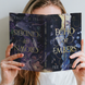 Person holding 'Echo of Embers' book by Tee Harlow in front of their face