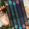 Row of book spines with decorative designs and titles on a blurred natural background