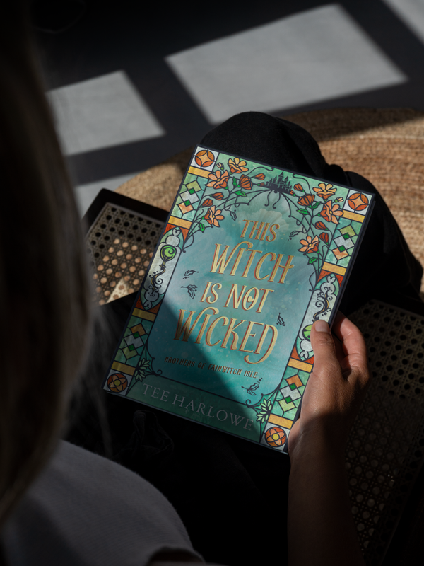 Book titled 'This Witch is Not Wicked' held by a person with a dark background